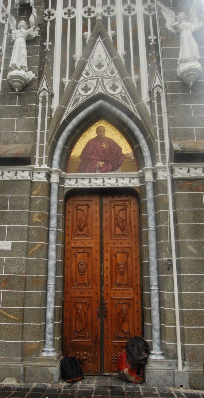 My bags sheltering from the rain as I photograph Las Lajas cathedral on the border of Colombia and Ecuador.